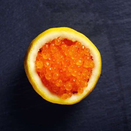 Red caviar in a fresh lemon cropped.の写真素材