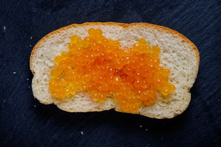 Caviar.spoon with red caviar on a black backgroundの写真素材