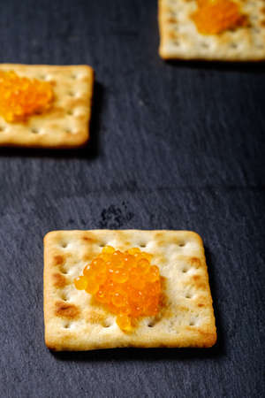 Caviar.spoon with red caviar on a black background