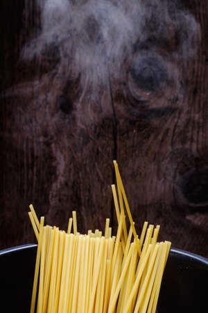 Some spaghetti are cooking in hot waterの写真素材