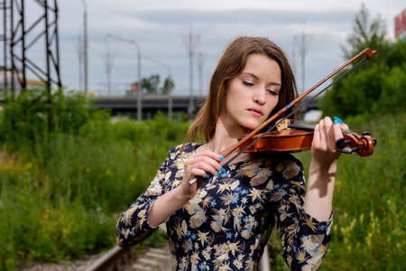 Beautiful woman performer with violin in natureの写真素材