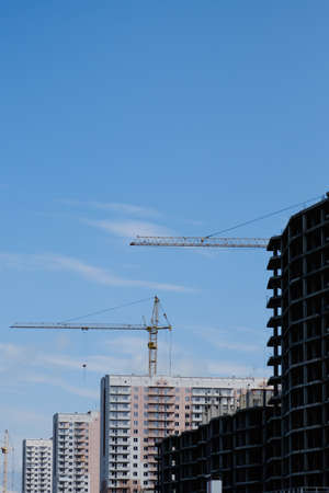 Construction site with cranes on sky backgroundの写真素材