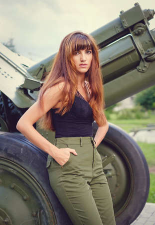 Beautiful red-haired young woman, pants, black top and bags walking on the streetの写真素材