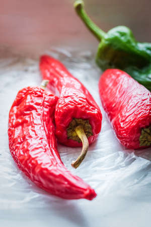 Red and green peppers illuminated with light from a windowの写真素材
