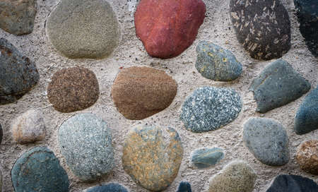 The stones embedded in the concrete foundation and backgroundの写真素材