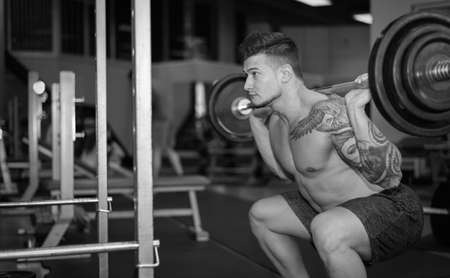 young man is engaged in bodybuilding at the gymの写真素材