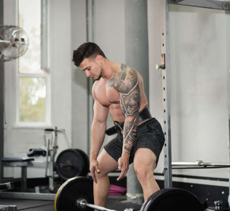 young man is engaged in bodybuilding at the gymの写真素材