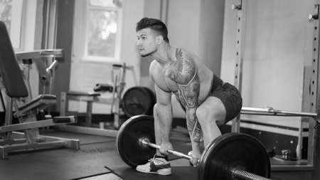 young man is engaged in bodybuilding at the gymの写真素材