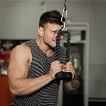 young man is engaged in bodybuilding at the gym