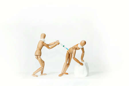 Wooden mannequins, on a white background. Vaccination.