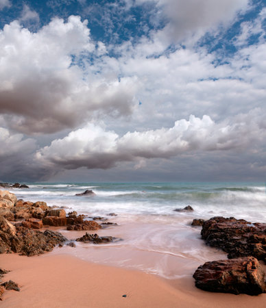 Tropical beach under cloudy sky. Costa Paradiso, Sardiniaの写真素材