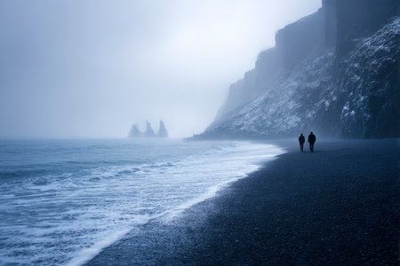 Foggy image of a couple walking on the beach in Icelandの素材