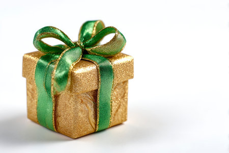 Gold gift box with green bow isolated on white background. Christmas decoration.の素材