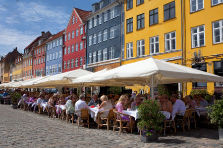 People sitting in a restaurant in Copenhagen. Copenhagen is the capital and largest city of Denmark.の素材