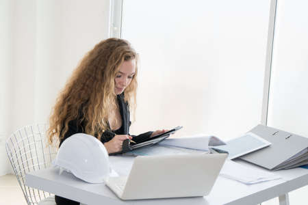Caucasian Engineer/Businesswoman working on laptop in her workstation.