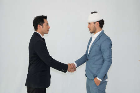 Two business man checking hand to success deal after meeting while another people applauding. white backgroundの写真素材