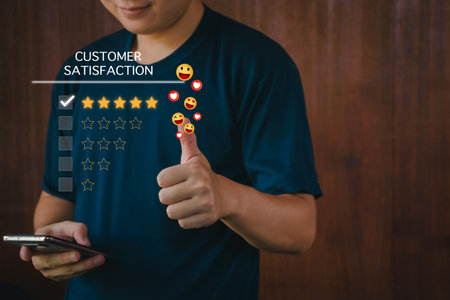 Customer satisfaction assessment concept, man using smartphone smiling and thumbs up, rate five stars, send smiley emoji and hearts, satisfied smiley face, excellent service, customer be happy.の写真素材