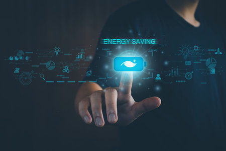 Energy saving concept. Person touching the battery saver button. On the virtual screen, help save energy, reduce global warming, save the environment, reduce pollution, eco-technology.の写真素材