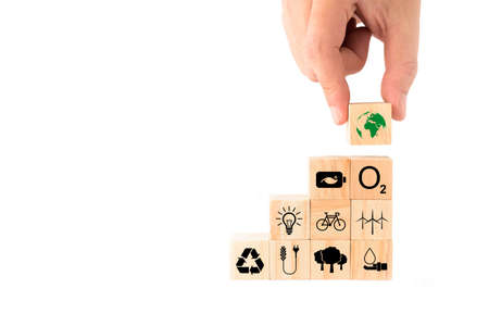 Ideas to save the environment for World Environment Day. hand picking up wooden blocks with Earth icon on top. energy saving, clean energy, reforestation, increase oxygen, reduce fuel consumption.の写真素材
