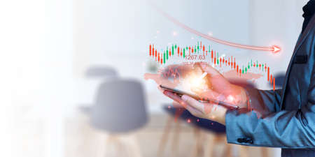 Concept, stock chart is falling during the global economic crisis. businessman using smartphone Check stock market prices online, sell stocks, economy is bad due to international conflicts.の写真素材