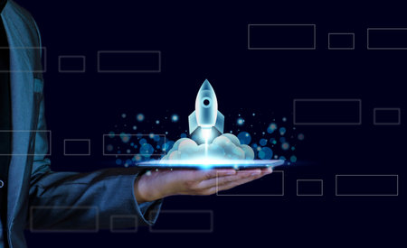 Startup business concept. Businessman holding a tablet, rocket launching and soar flying out from...