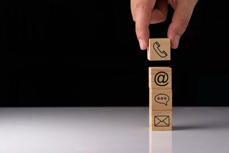 Website page contact us or e-mail marketing concept, Customer support hotline Contact us people connection. cube wood with the email, call phone, address, Chat message icons. on keyboard computer.の写真素材