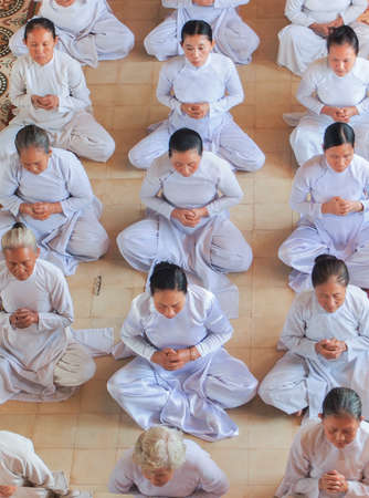 TAY NINH, VIETNAM - MARCH 3, Meditating followers of the Cao Dai religion in the temple Cao Dai on MARCH 3, 2013のeditorial素材