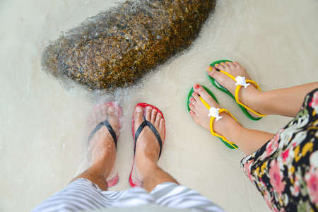 Colorful flipflop sandals on sea beachの写真素材