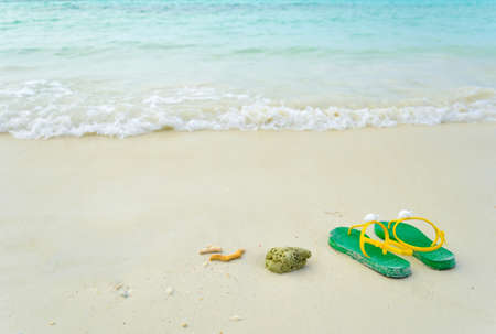 Green flipflop sandals on sea beachの写真素材