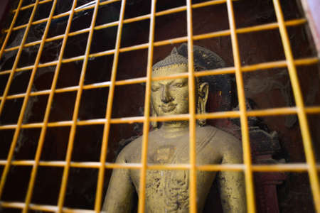 Bagan, Myanmar - April 22, 2016 :  Historic Buddha images in a protective cage at Ananda Temple in Bagan, Myanmarの写真素材