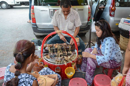 Yangon, Myanmar - April 25, 2016 : Burmese eating Pork offal skewers with hot soup in Yangon,  Pig tail, Myanmar street foodのeditorial素材