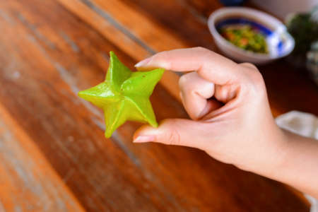 Star fruits on hand,  Tropical fruit,   wooden table.の写真素材