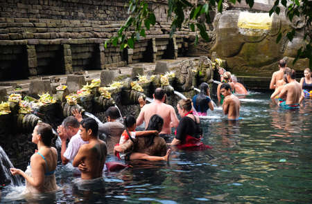 Bali, Indonesia - September  9,2017:  foreigner worshippers pray in the water at the Tirta Empul Temple . Believe that water from the spring is holy and has the healing power.のeditorial素材