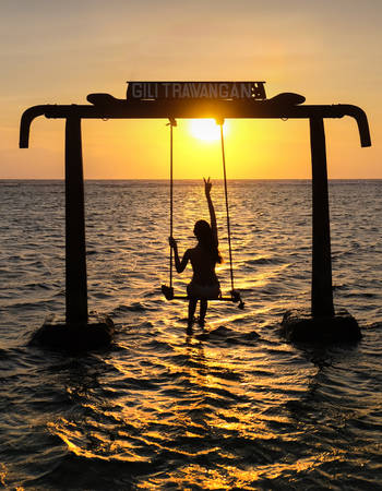 Gili Trawangan, Indonesia - September 11, 2017:  Silhouette of Beautifull Gate with girls swing above ocean sunset.   Gili Trawangan island, Lombok, Indonesiaのeditorial素材