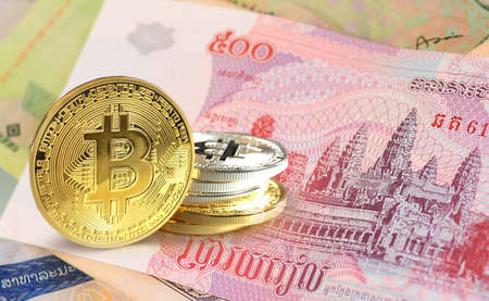 Bitcoin coins on Cambodian riel banknote, Cryptocurrency concept photo