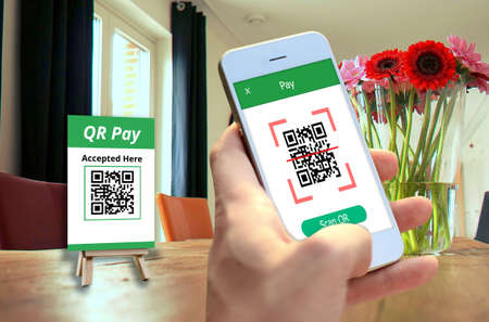 Hand holding smartphone to scan QR code payment , online shopping , cashless technology concept.
