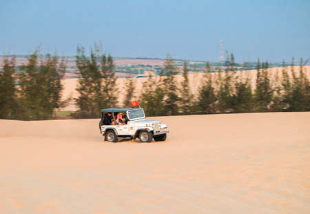 Off road car vehicle in white sand dune desert at Mui Ne, Vietnamのeditorial素材