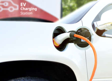 Electric car (EV) at charging battery at EV Charge station with the power cable supply plugged in