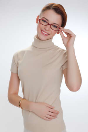 YOUNG BEAUTIFUL GIRL IN GLASSES AND BEIGE JACKETの写真素材