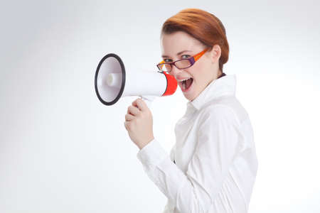 business woman is screaming to her associate with megafon  isolated white backgroundの写真素材