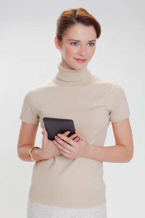 beautiful woman in a beige sweater with tablet computer isolated white backgroundの写真素材