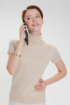 beautiful woman in a beige sweater with tablet computer isolated white backgroundの写真素材