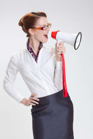 business woman is screaming to her associate with megafon  isolated white backgroundの写真素材