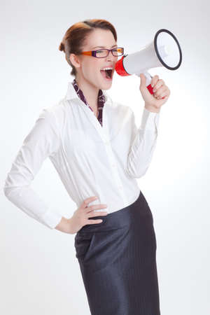 business woman is screaming to her associate with megafon  isolated white backgroundの写真素材