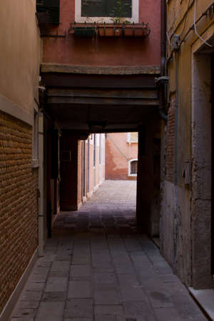 Historic houses dark alleyway in Venice italyの写真素材