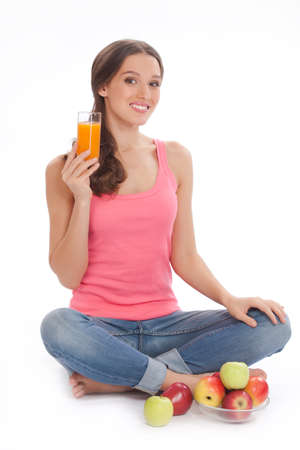 pretty excited  happy smileyoung woman holding glass of orange juice in hand over white backgroundの写真素材