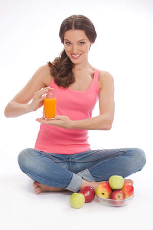 pretty excited  happy smileyoung woman holding glass of orange juice in hand over white backgroundの写真素材