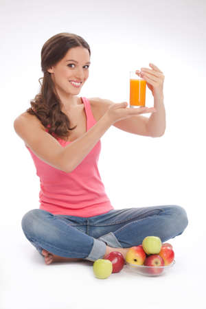 pretty excited  happy smileyoung woman holding glass of orange juice in hand over white backgroundの写真素材