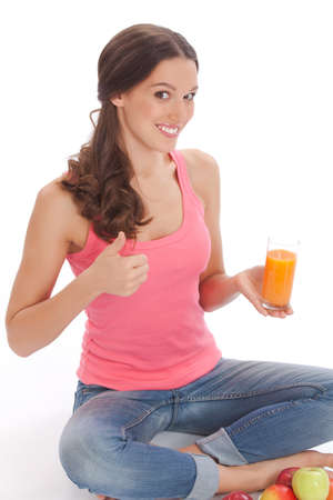 pretty excited  happy smileyoung woman holding glass of orange juice in hand over white backgroundの写真素材