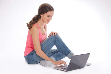 Beautiful young woman with laptop  on white backgraundの写真素材